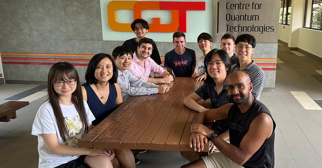 Members of Ng Hui Khoon's research group at the Centre for Quantum Technologies seated around a picnic table.